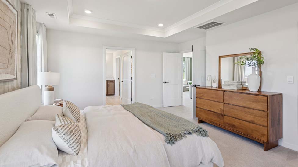 Carpeted primary bedroom with windows
