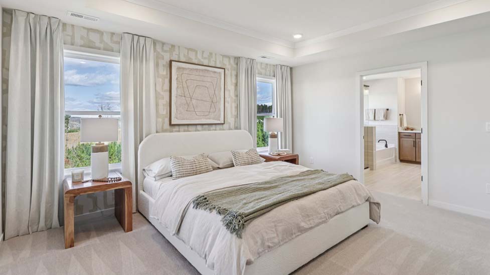 Carpeted primary bedroom with windows