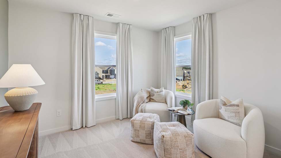 Carpeted primary bedroom with windows