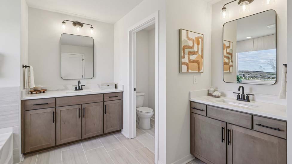 Primary bathroom with double sinks and standing shower