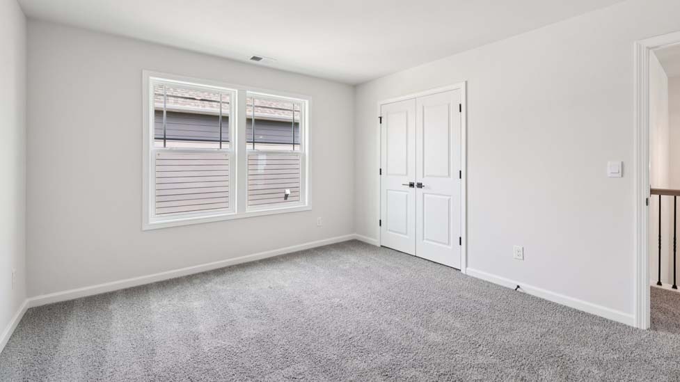 Carpeted bedroom with windows