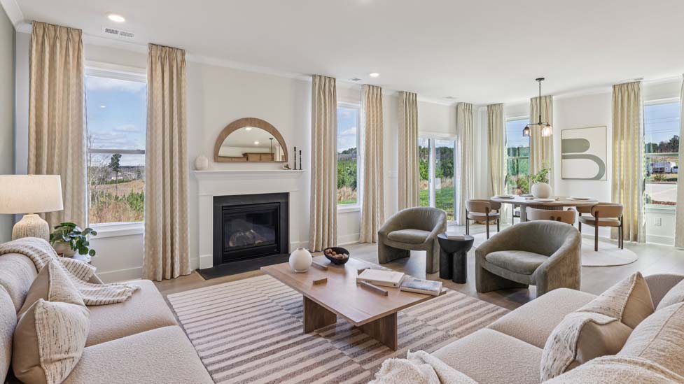 Open living room beside kitchen and dining with electric fireplace and large window