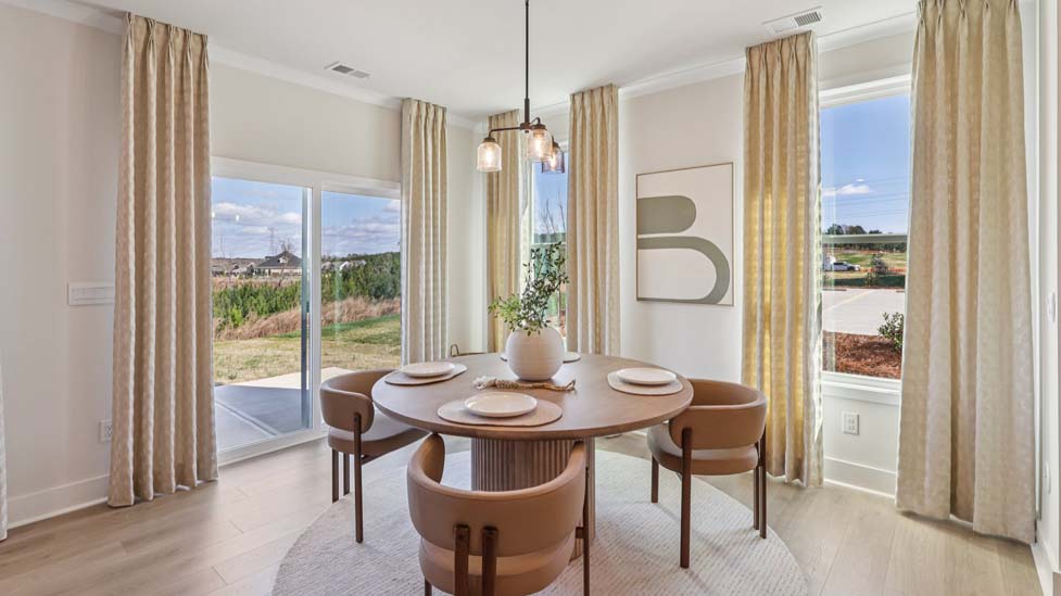 Open concept breakfast area beside kitchen with large windows
