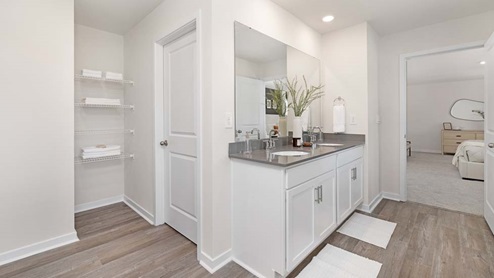 Primary bathroom with double sink vanity and standing glass door shower