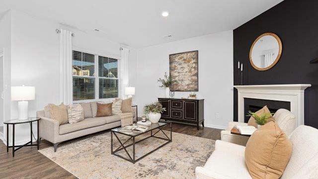 Open living room with ceiling fan and large window. New Home in Charlotte, North Carolina