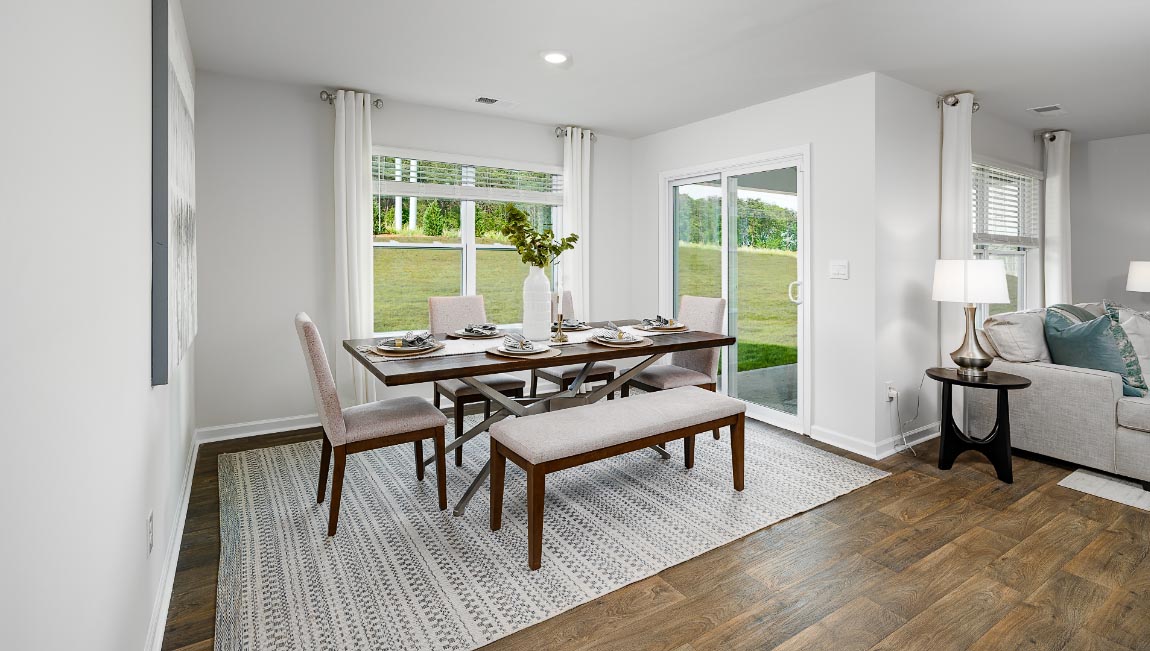 Dining area beside kitchen and living room with large windows and sliding glass back door. New Home in Charlotte, North Carolina
