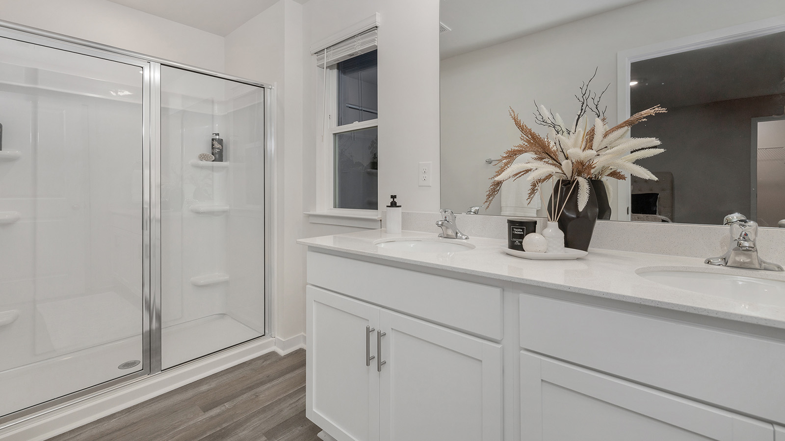 Primary Bathroom with double vanity and glass door shower