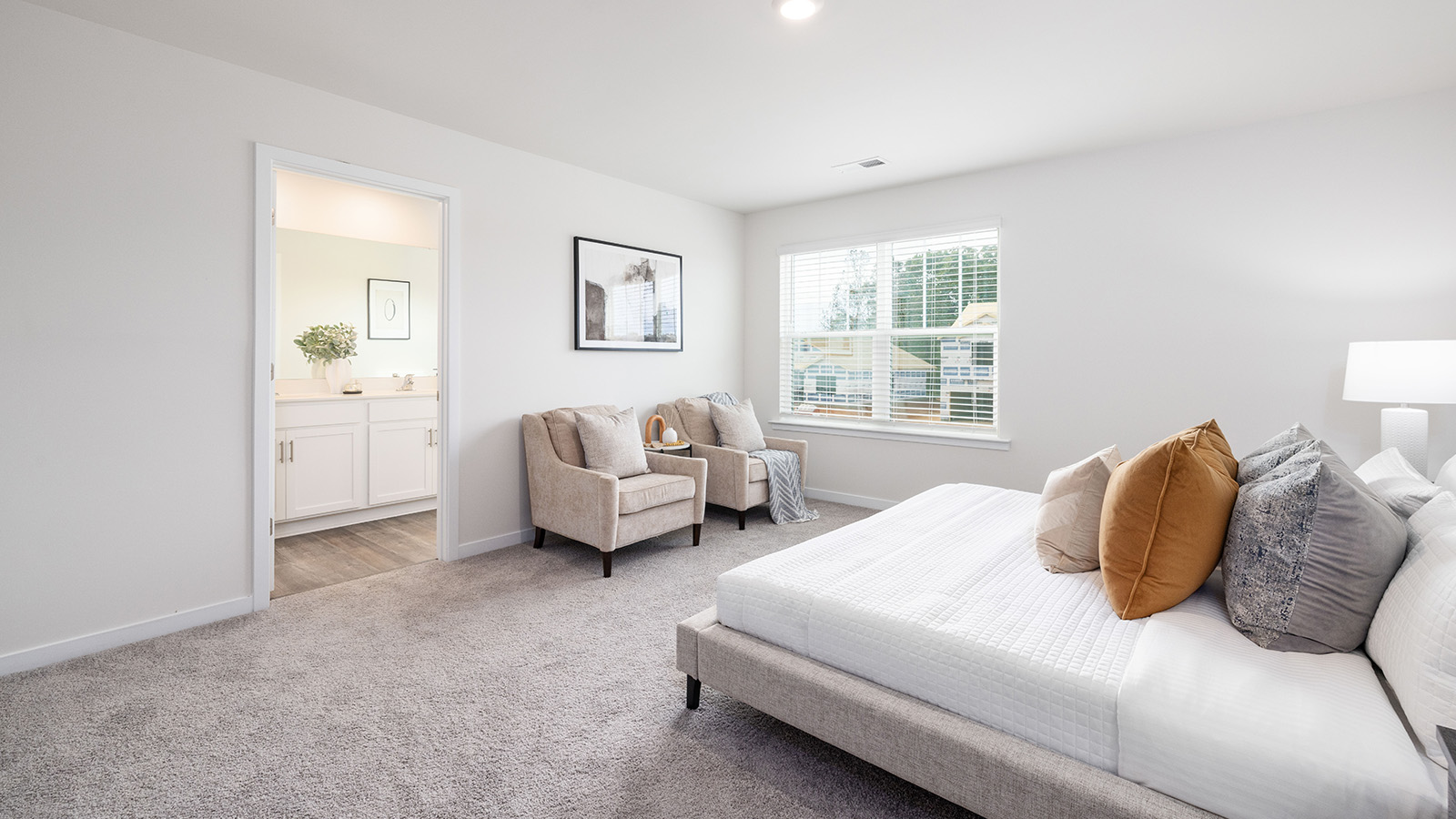 Primary bedroom carpeted with large window