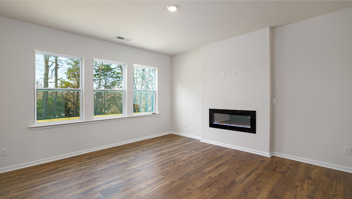 Living room space with wood floors, three large windows