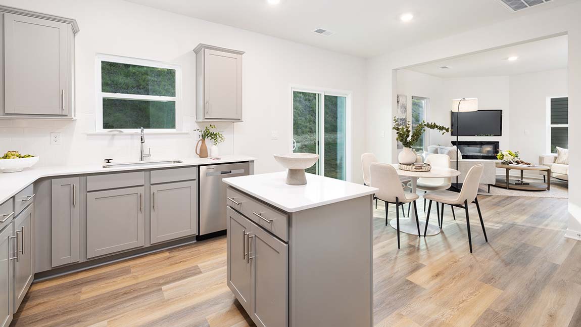 Kitchen and island, white cabinets and wood flooring