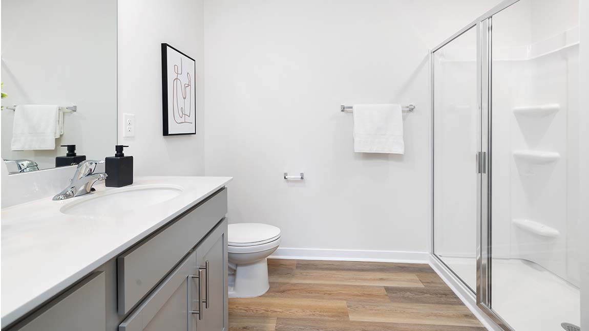 Primary bathroom with double sinks, white counters and cabinets