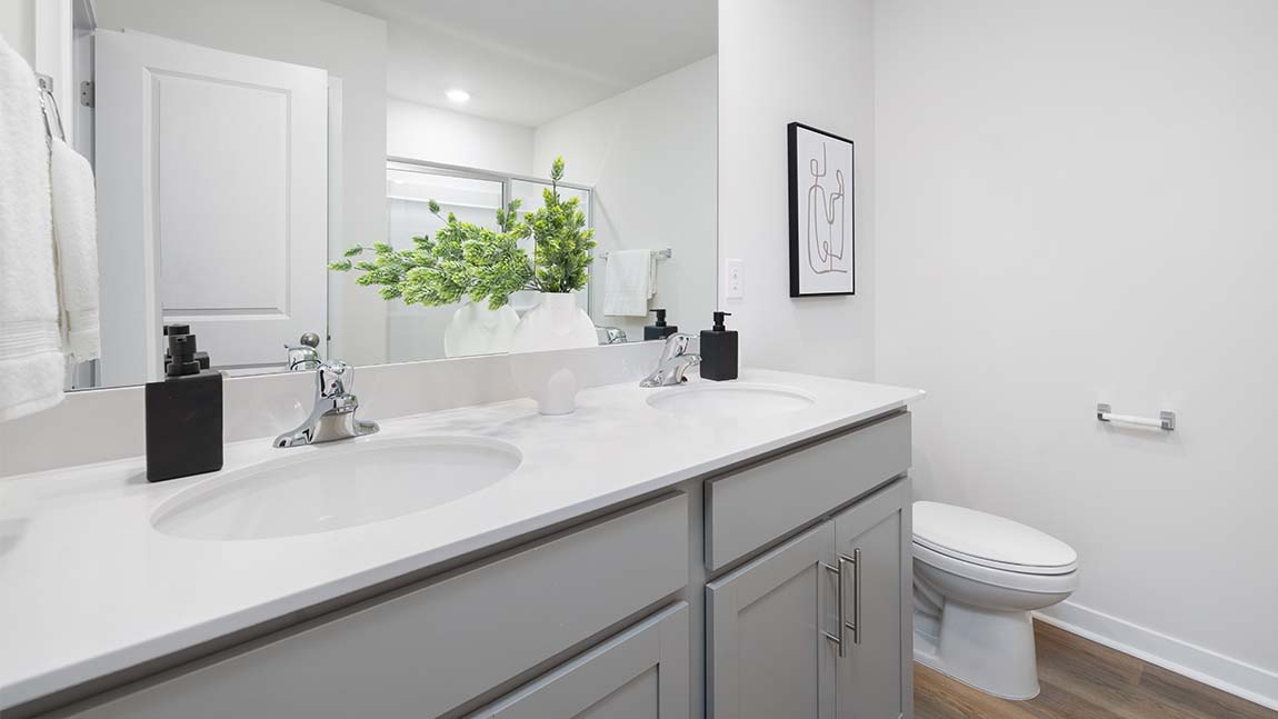 Primary bathroom with double sinks, white counters and cabinets