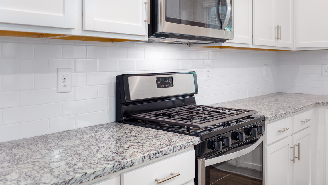 Kitchen and island, white cabinets and wood flooring