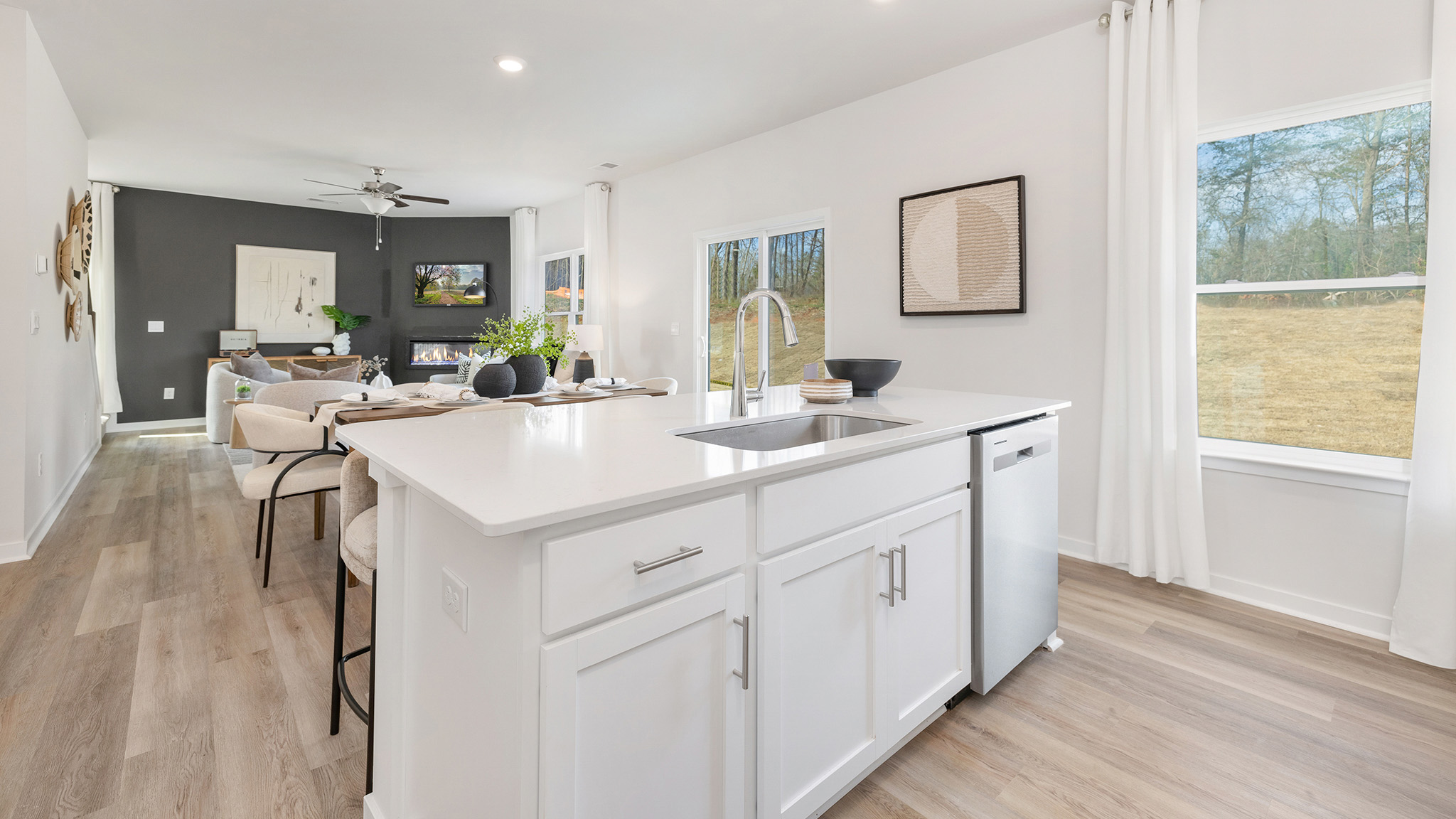 kitchen and island with white cabinets, wood floors and stainless steel appliances
