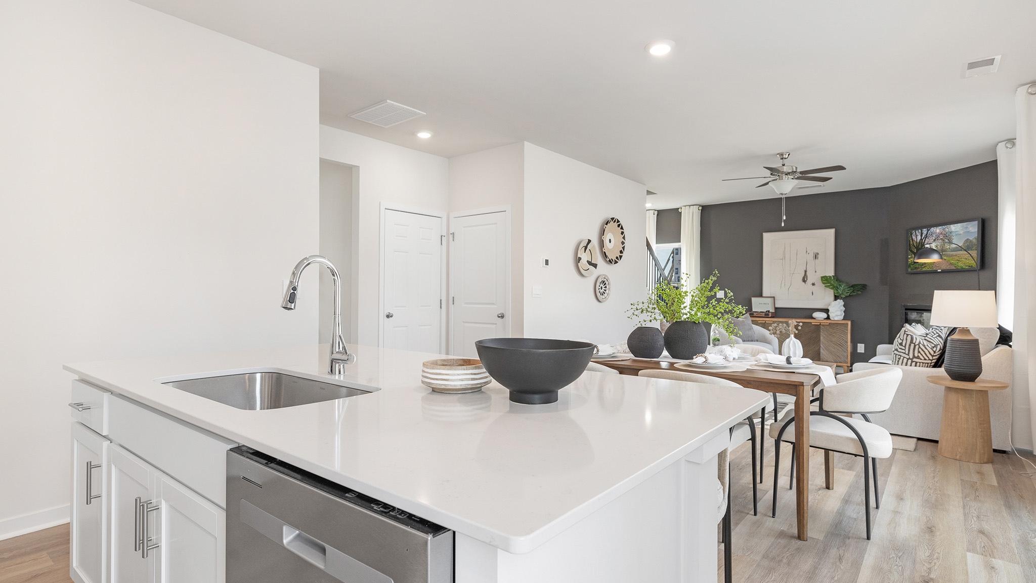 kitchen and island with white cabinets, wood floors and stainless steel appliances