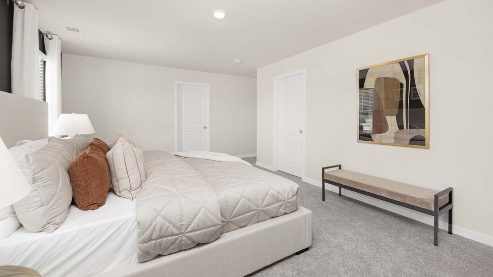 Carpeted primary bedroom with large windows