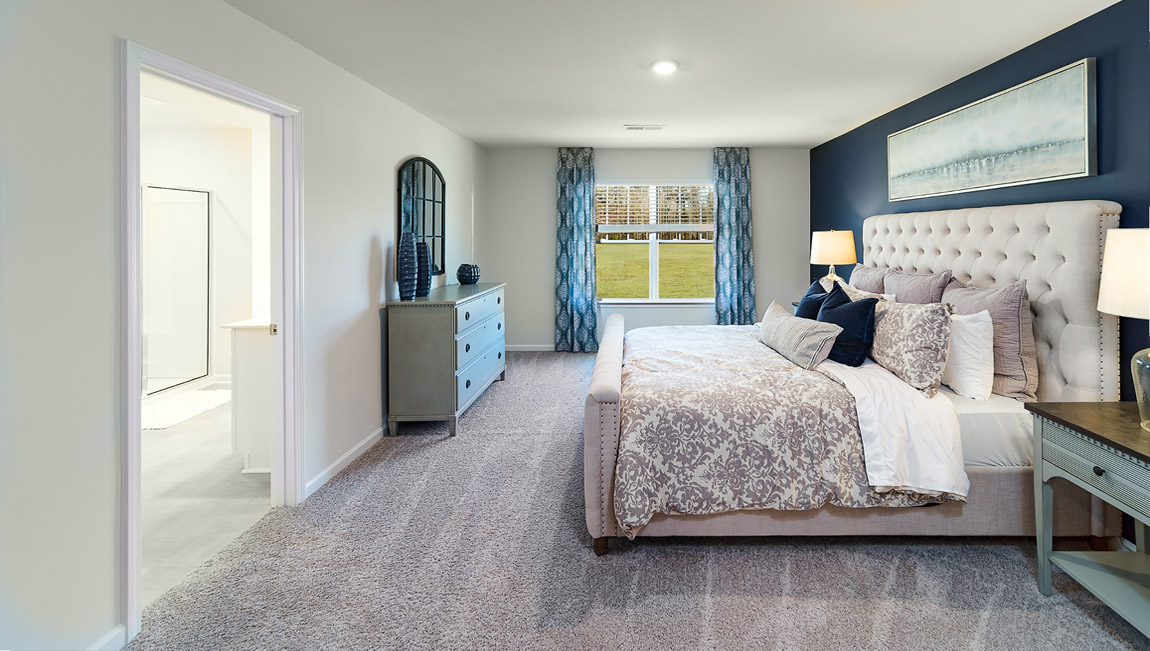 Model carpeted bedroom with small window