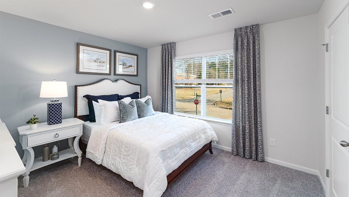 Model carpeted bedroom with small window