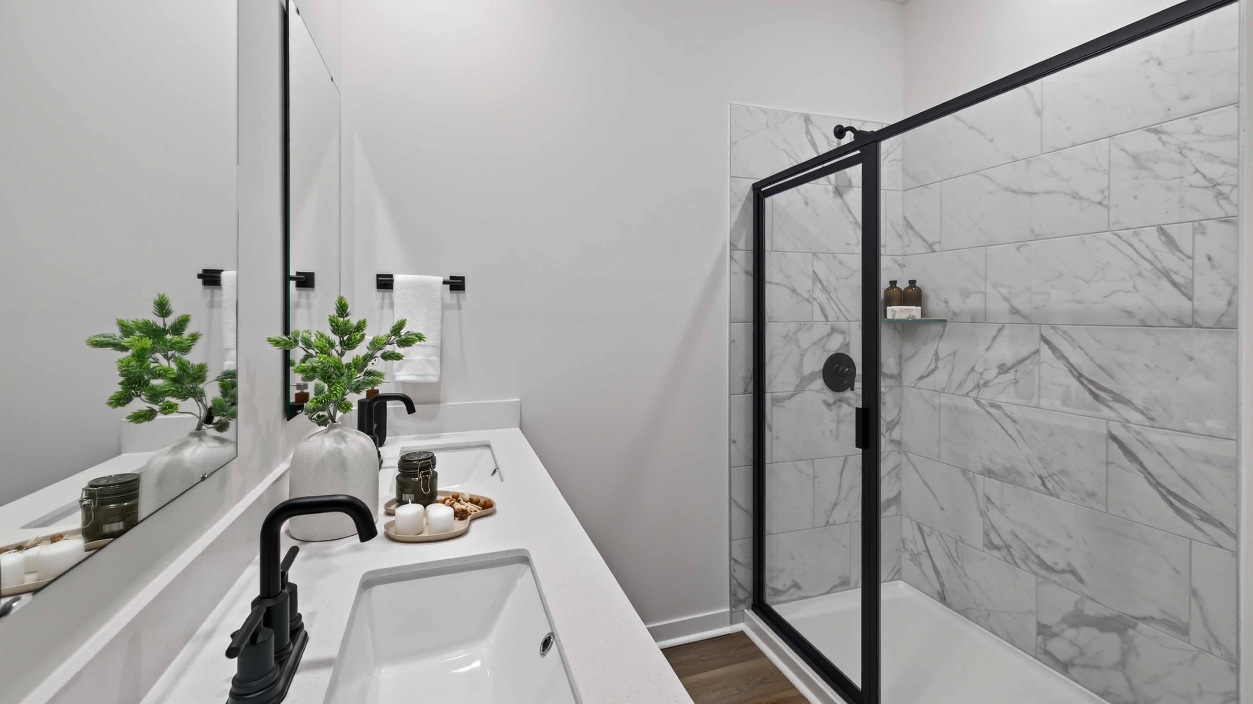 Primary bathroom with standing glass shower and double sinks