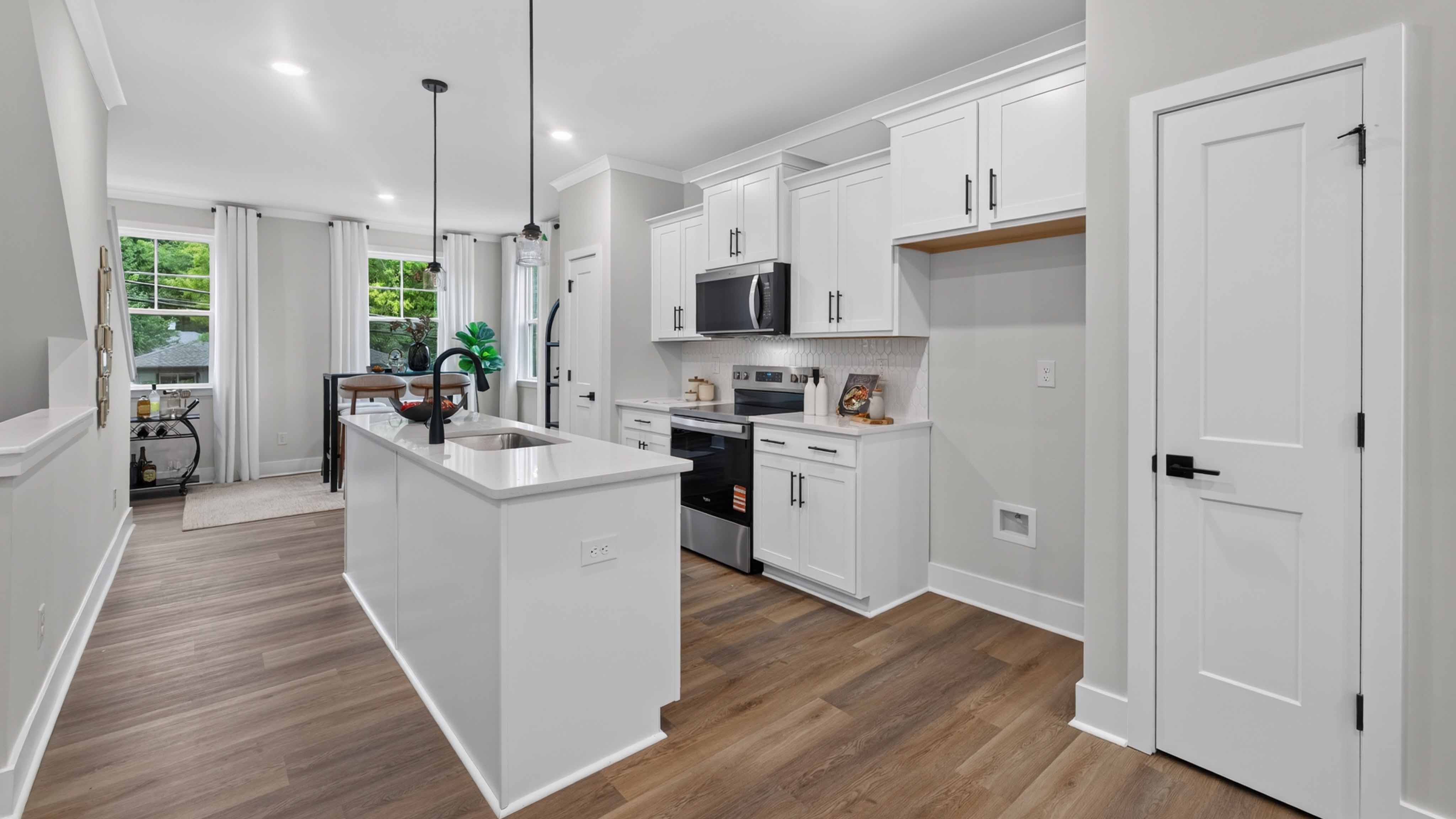 Kitchen and island with black hardware and stainless steel appliances