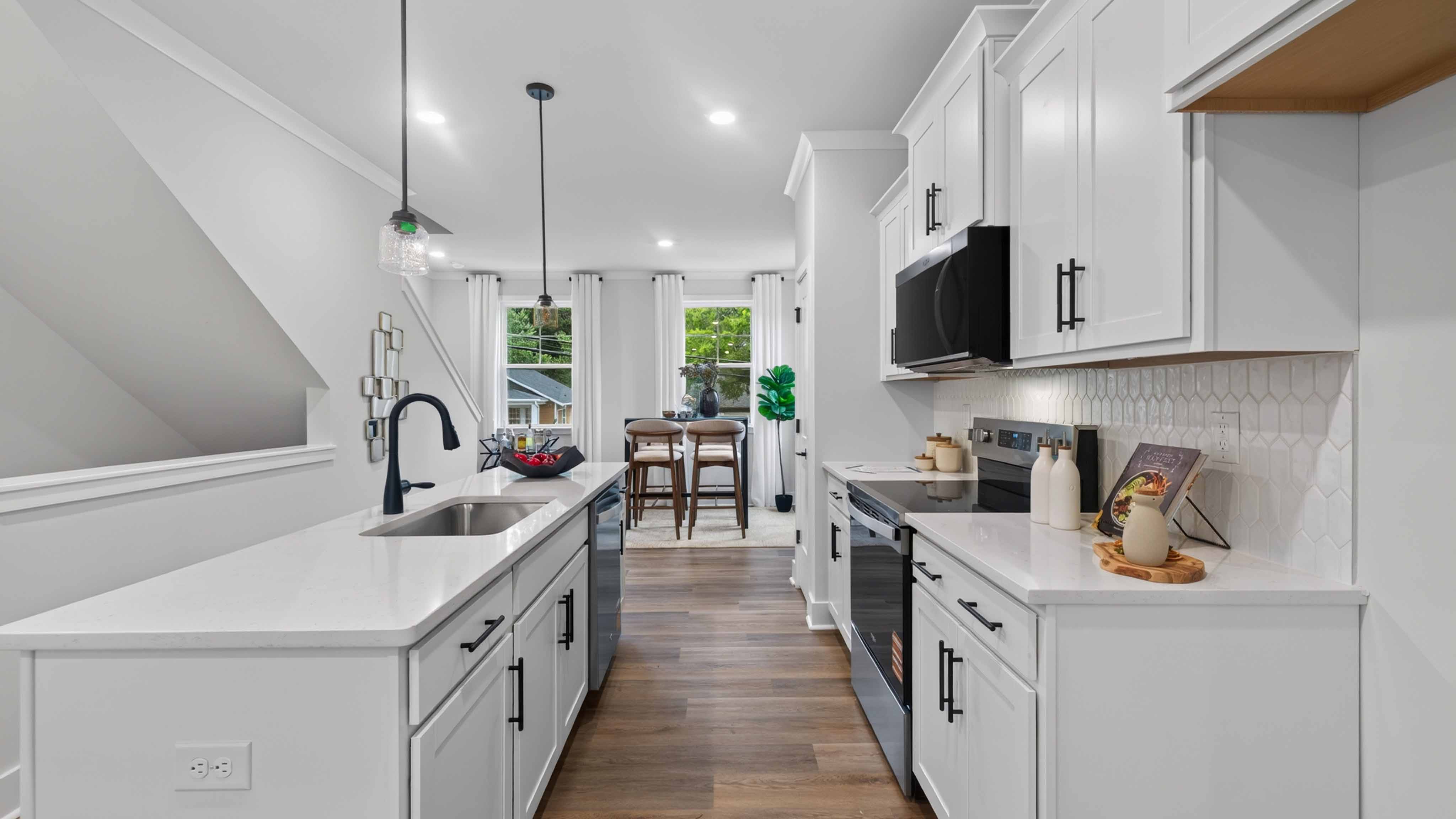 Kitchen and island with black hardware and stainless steel appliances