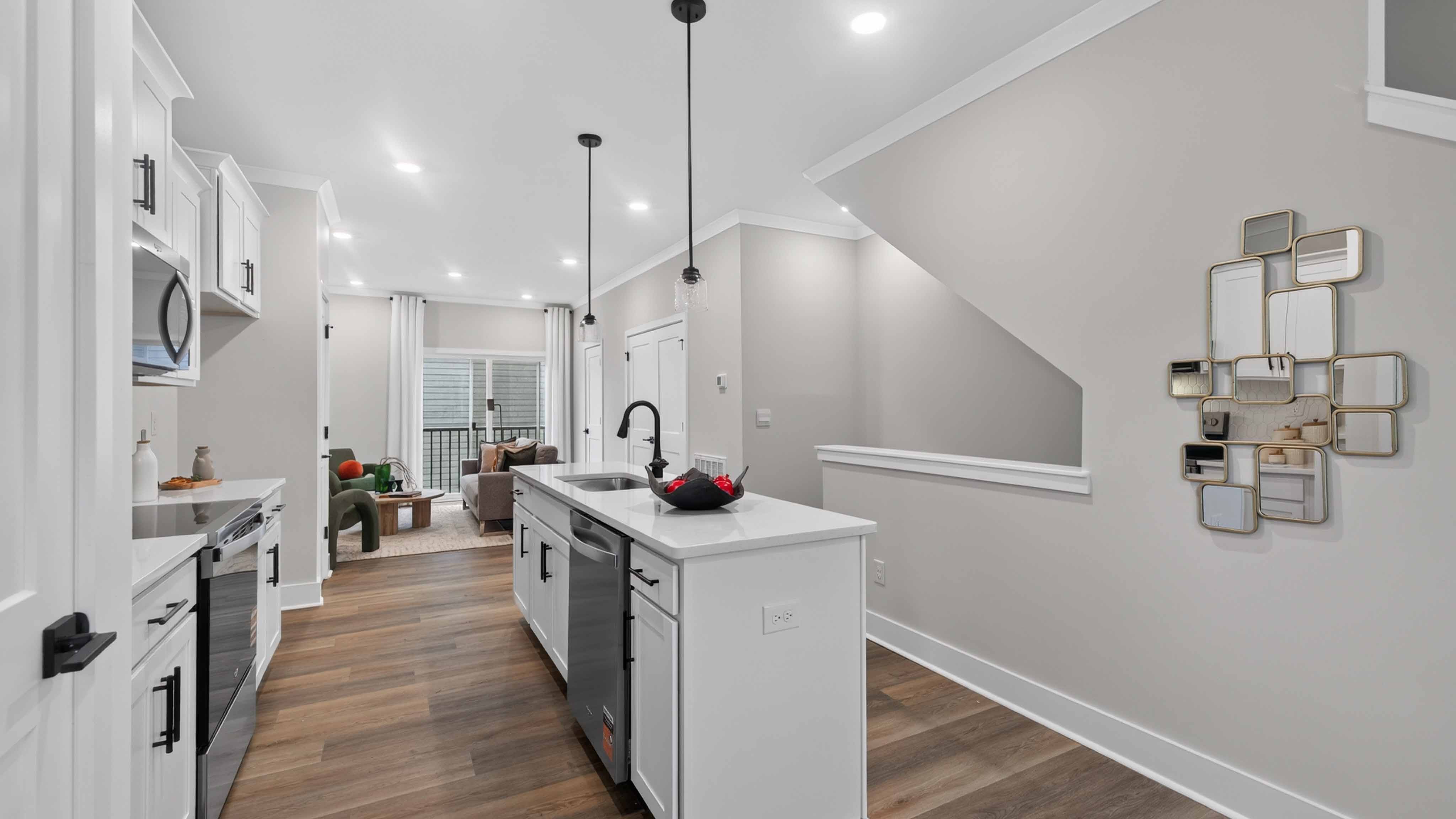 Kitchen and island with black hardware and stainless steel appliances