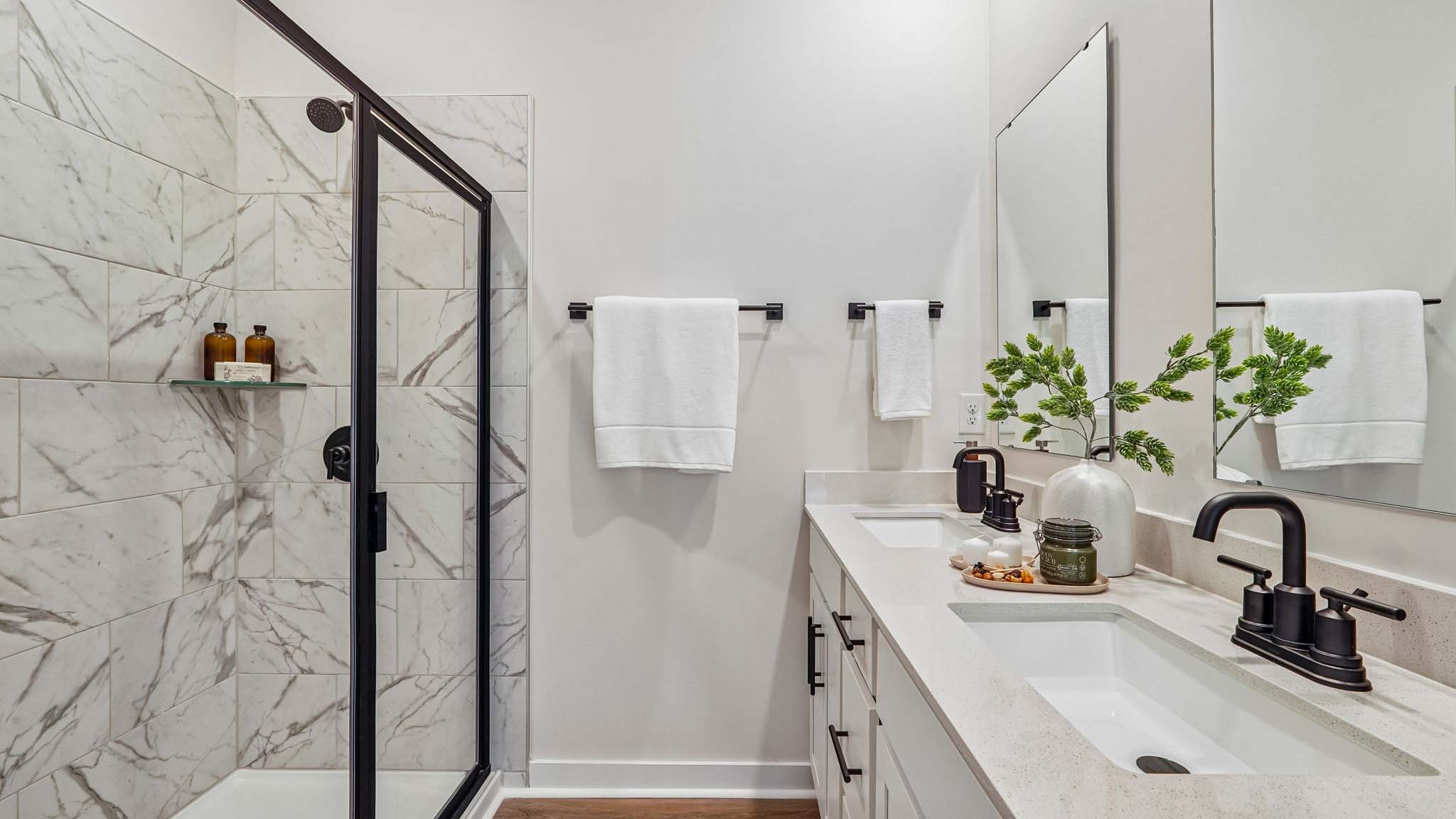 Primary bathroom with standing glass shower and double sinks