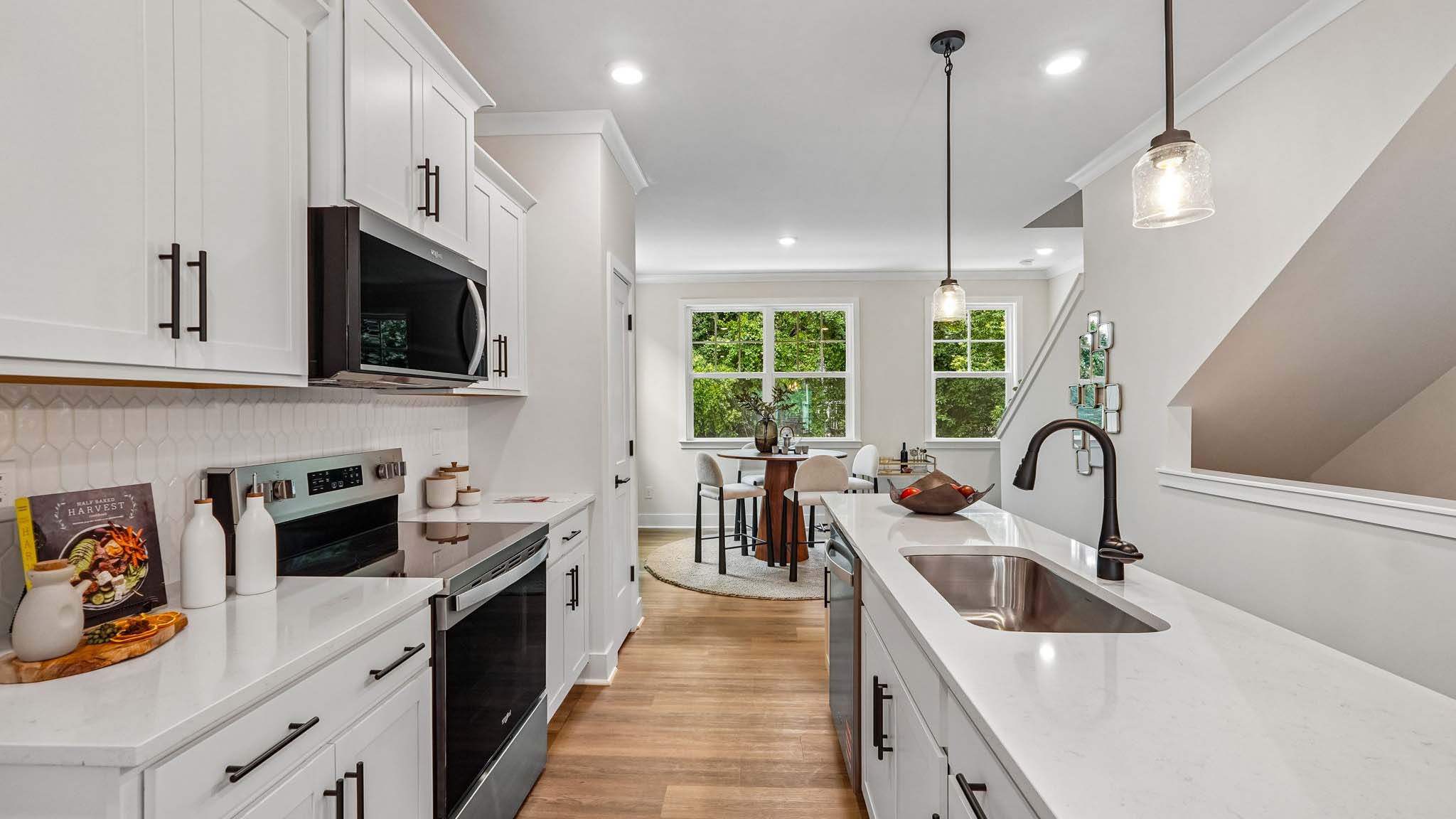 Kitchen and island with black hardware and stainless steel appliances