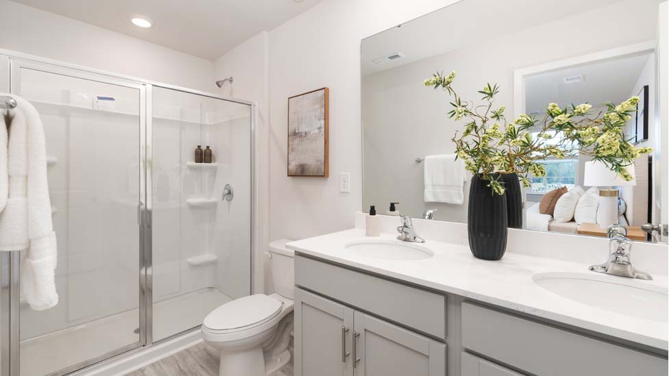 primary bathroom with standing shower and double sink vanity
