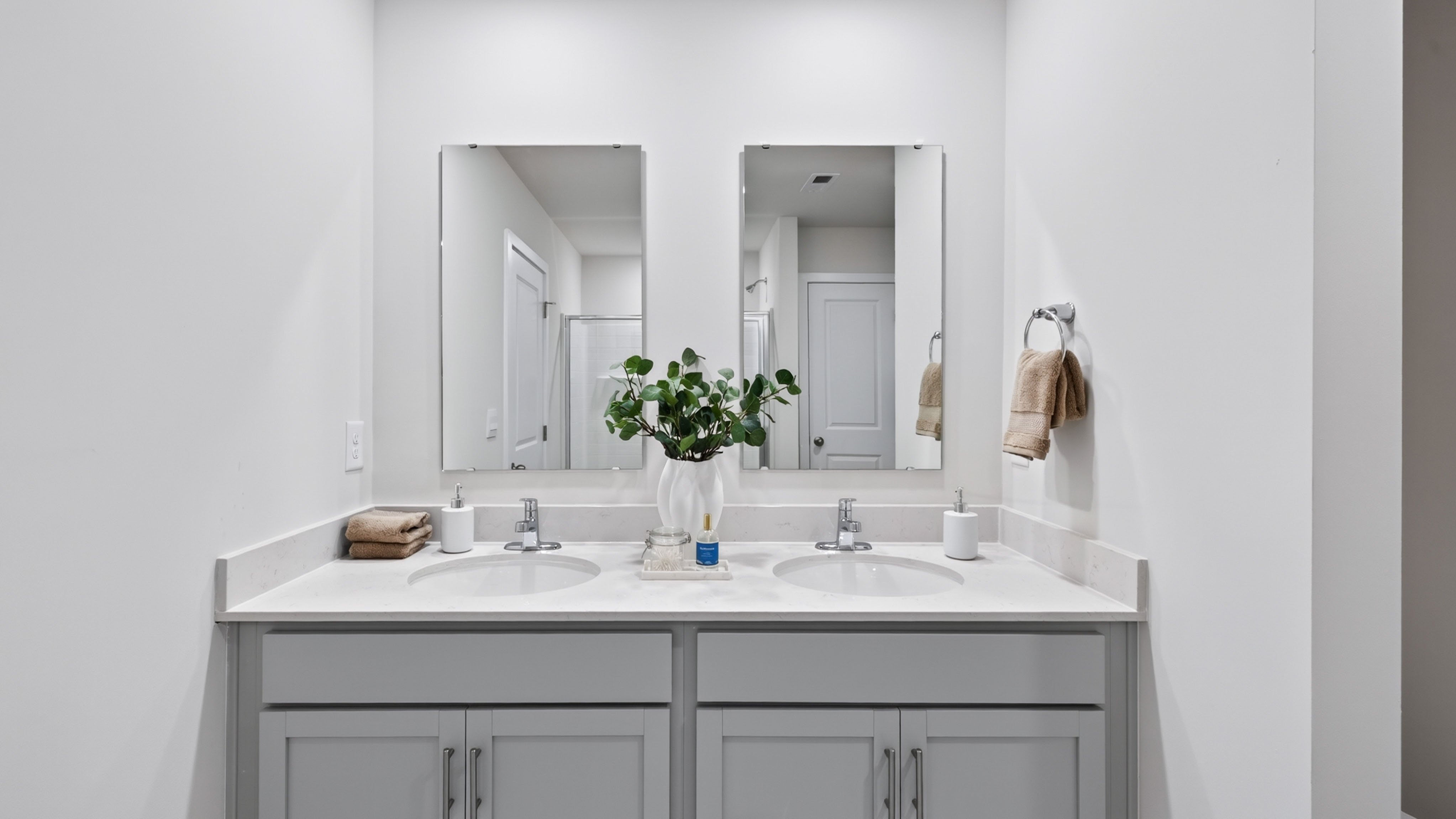 primary bathroom with standing shower and double sink vanity
