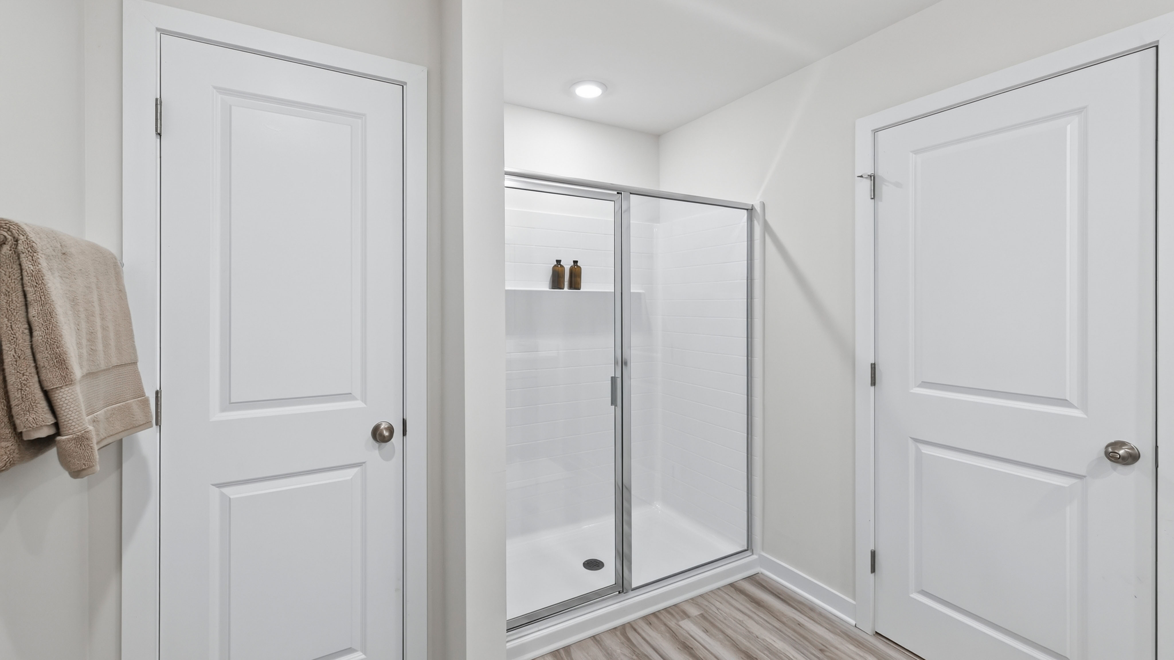 primary bathroom with standing shower and double sink vanity