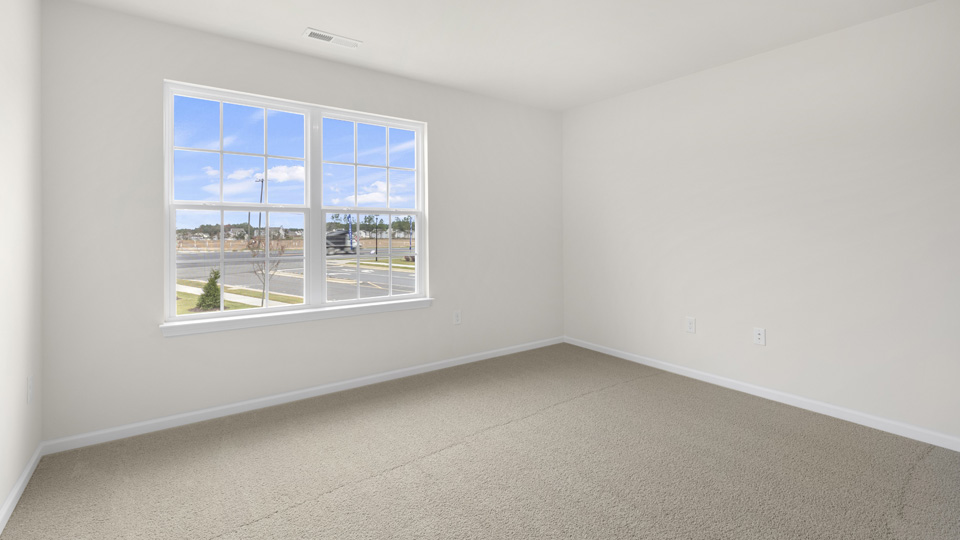 main bedroom with window view carpet flooring