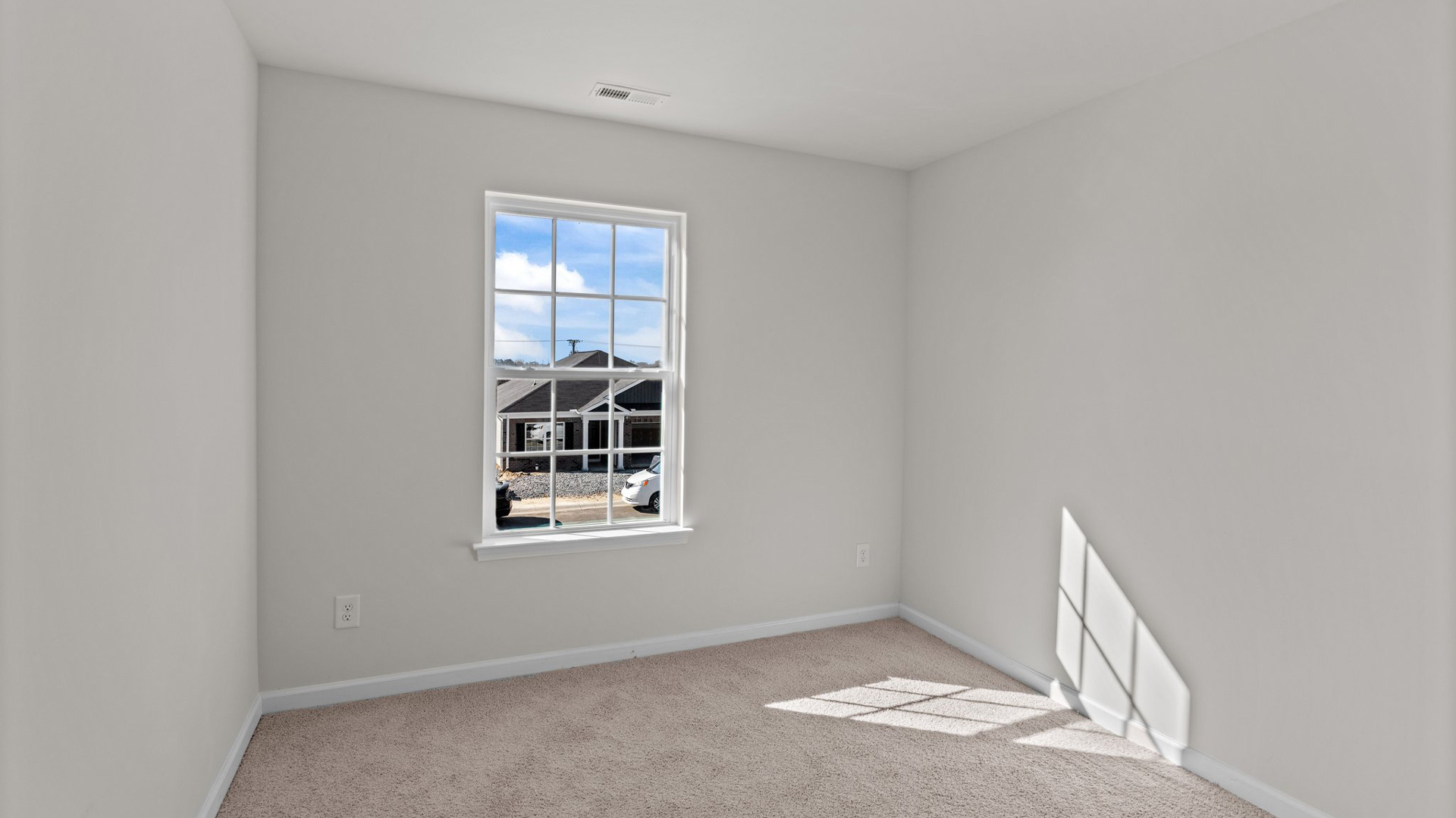 secondary bedroom with window and carpet