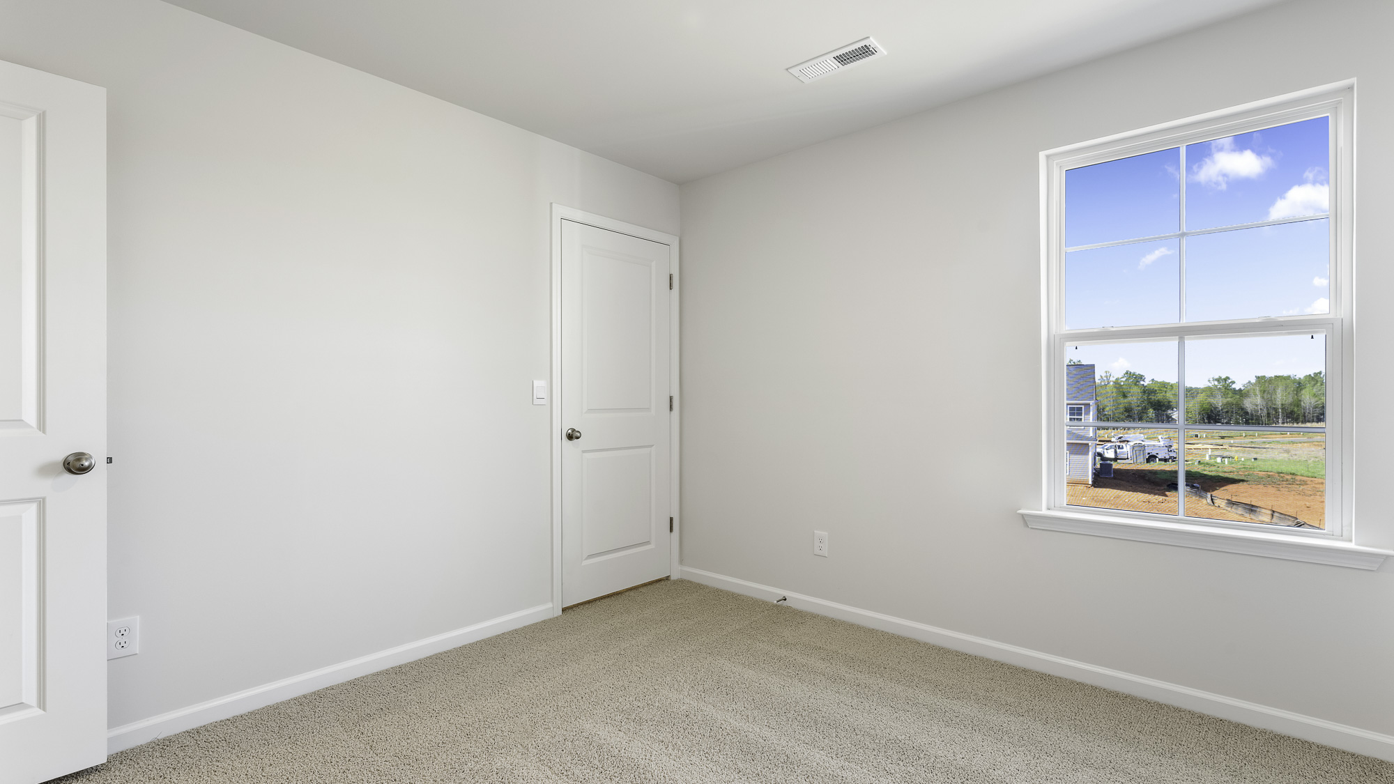 secondary bedroom with carpet and window