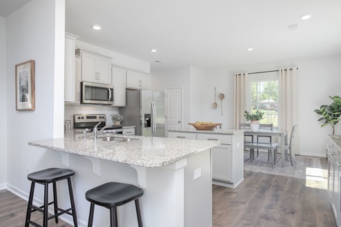 kitchen with revwood floors an island and stainless steel appliances