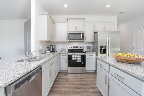 kitchen with revwood floors an island and stainless steel appliances