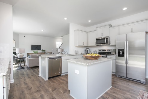kitchen with revwood floors an island and stainless steel appliances