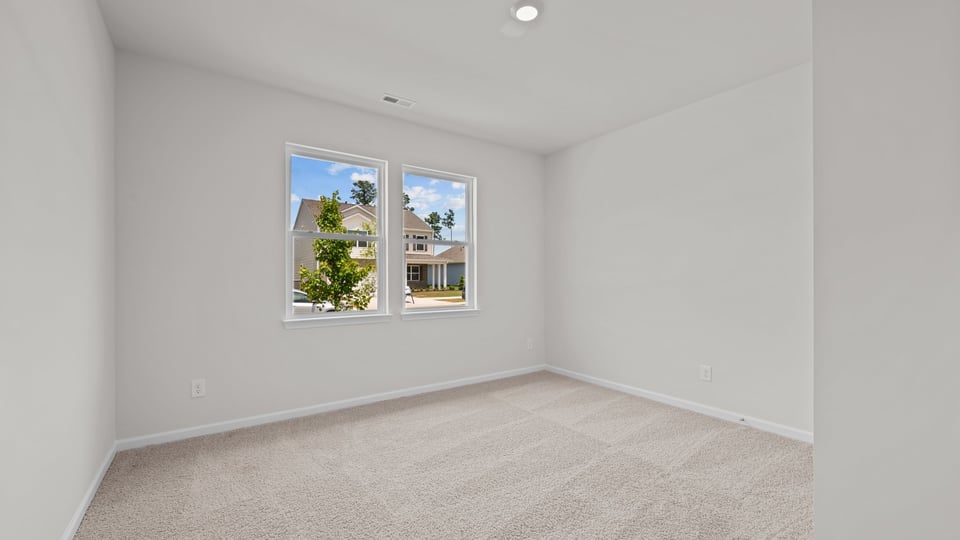 secondary bedroom with window and carpet