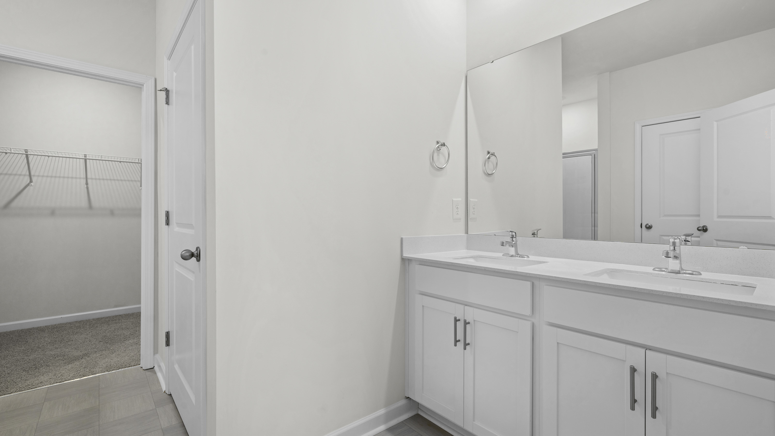 main bathroom with dual sink and walk-in closet