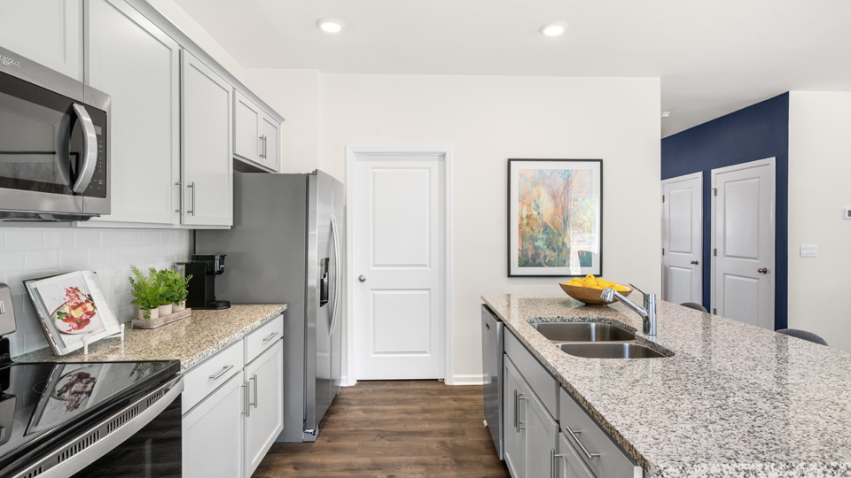 Kitchen with island, revwood flooring, shaker style cabinets and stainless steel appliances