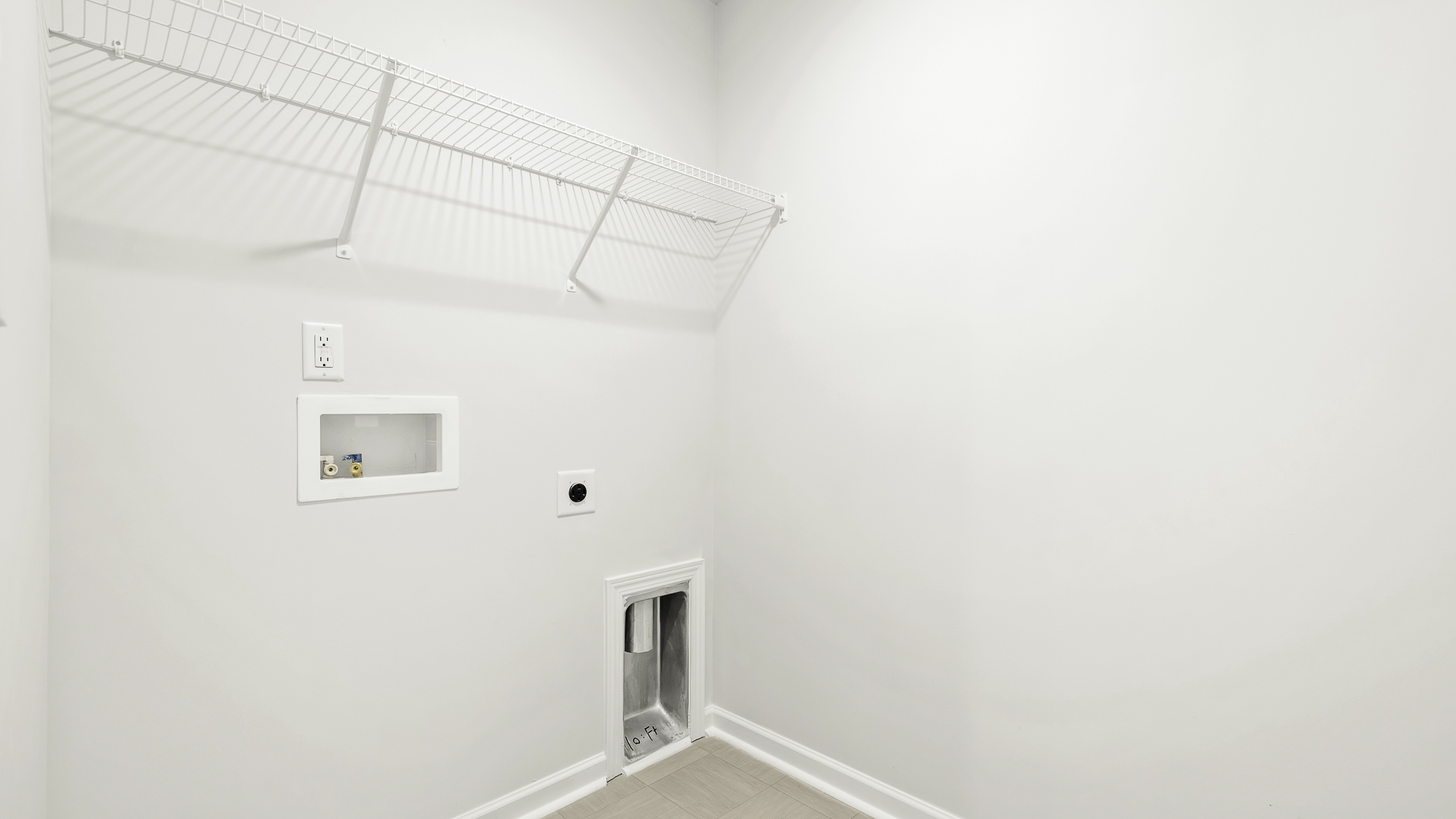 Dedicated utility area featuring white walls, installed wire shelving, and recessed plumbing hookups