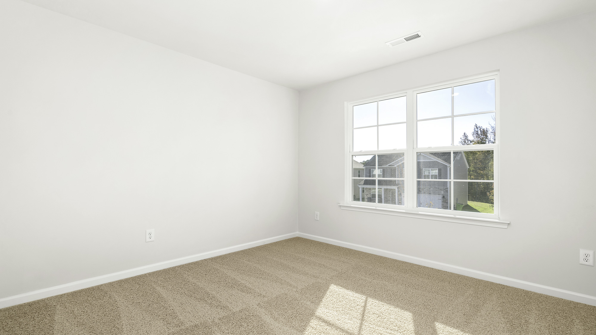 Neutral-toned carpeted flooring, white wall finishes, and double-pane windows with integrated grilles