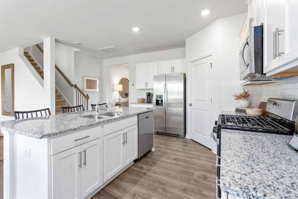 kitchen with island, revwood floor, and stainless steel appliances