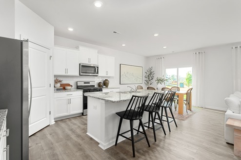 kitchen with revwood floors an island and stainless steel appliances