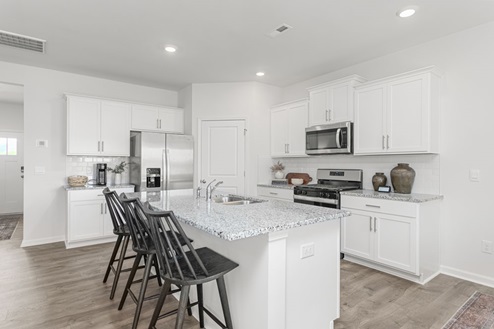kitchen with revwood floors an island and stainless steel appliances