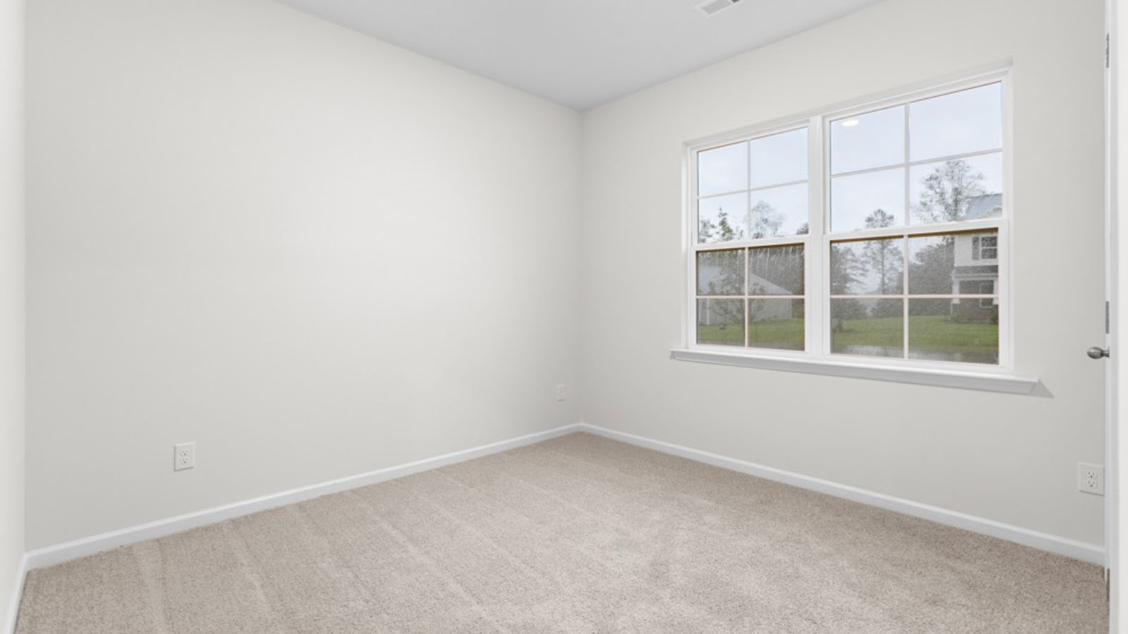 secondary bedroom with window view and carpet flooring