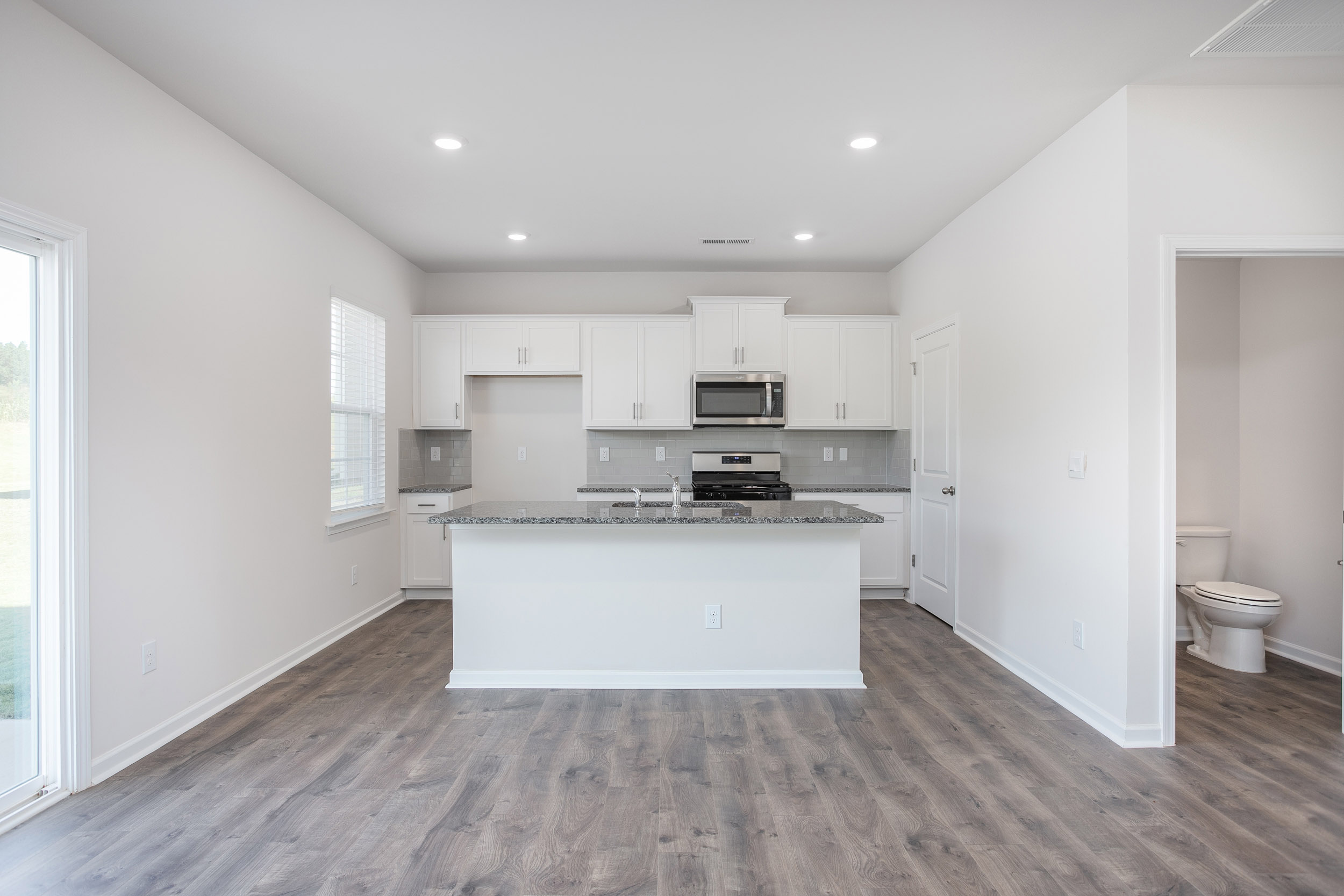 kitchen with island, revwood floors, and stainless steel appliances