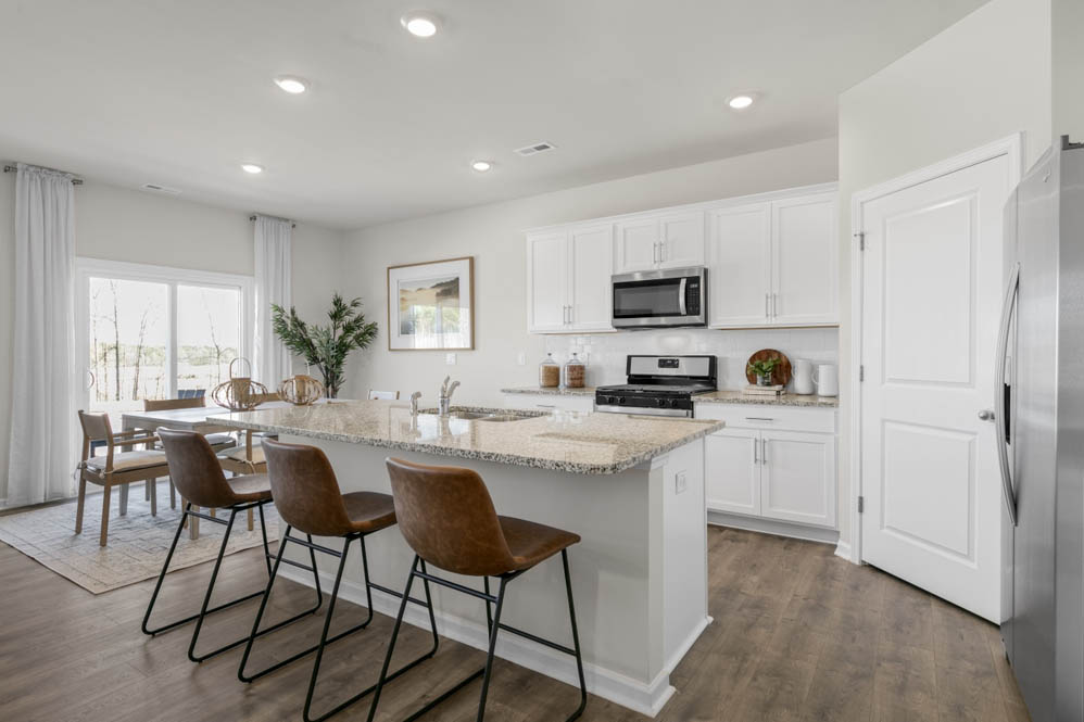 kitchen with island, revwood floors, and stainless steel appliances