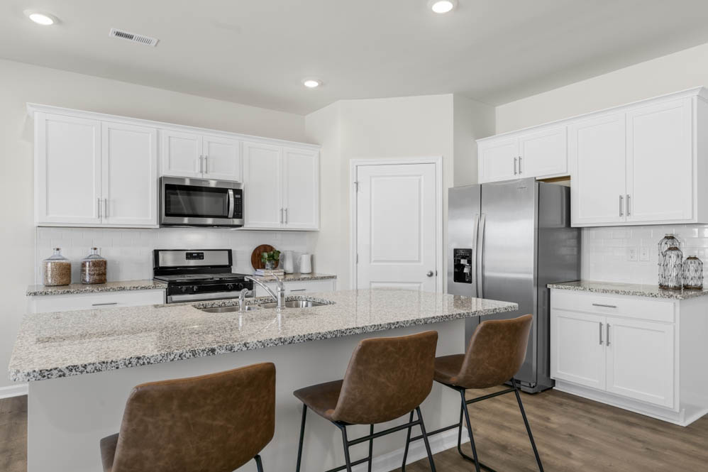 kitchen with island, revwood floors, and stainless steel appliances