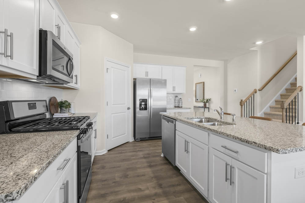 kitchen with island, revwood floors, and stainless steel appliances